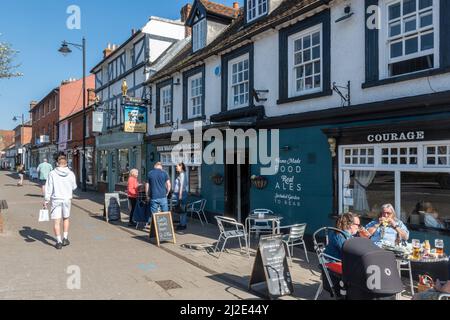 Hartley Wintney Village Centre, Hampshire, England, Großbritannien. Blick auf die High Street mit Menschen vor dem Wagon & Horses Pub Stockfoto
