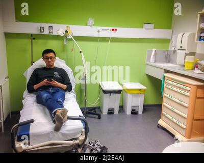 Paris, Frankreich, Chinesin, legt sich auf der Liege, wartet im Krankenhauszimmer, wartet auf Behandlung, Notaufnahme, Krankenhausinnenräume Stockfoto
