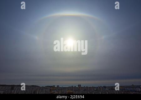 Sehr seltenes atmosphärisches Phänomen, genannt Sonnenhalo, verschiedene Sonnenhalos, die am Himmel in der Stadt erscheinen Stockfoto