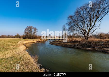 Der Fluss Odra mit dem Dorf Petrvaldik im Hintergrund in CHKO Poodri in Tschechien während eines schönen Frühlingstages Stockfoto