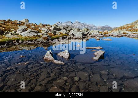 Die Schweizer Alpen vom Bergseeli aus gesehen: Ein kleiner, hochalpiner See an der Grenze zwischen der Schweiz und Italien, in der Nähe des Spluga Passes Stockfoto