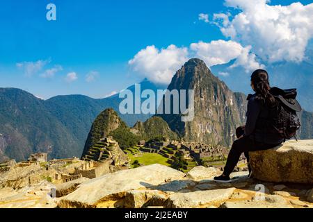 Eine Frau, die den Blick auf die Zitadelle Machu Picchu in Peru genießt Stockfoto