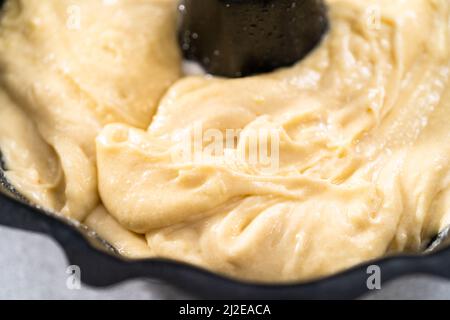 Zitronenpfaumteig in einer gebrannten Backform, fertig zum Backen. Stockfoto