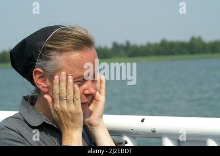 Wigry Podlasie Poland Polen, Polska, Porträt einer gebräunten Nonne vor einem Seegrundgrund. Porträt einer Nonne auf dem Hintergrund des Sees. Zakonnica Stockfoto