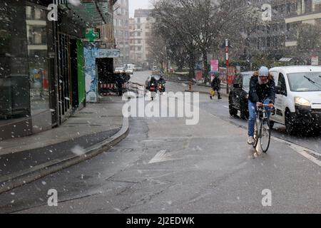 Genf, Schweiz, 2022-04-01 der Radfahrer steht auf der Straße vor dem Schnee. Der erste Apriltag hat mit winterlichen Wetter begonnen. Kredit: marcio cimatti/Alamy Live Nachrichten Stockfoto