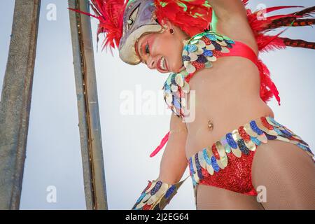 Portugal Karneval - Grupo Costa de Prata - Ovar 2016 Karnevalsparade in Ovar. Junge lächelnde Frau, die in einem rot-gefiederten Kostüm im brasilianischen Stil auftrat. Stockfoto