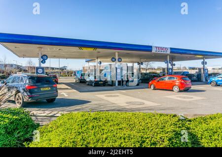 Autos, die sich auf dem Vorplatz einer Tankstelle in einem Tesco-Supermarkt den Benzinpumpen nähern. Stockfoto