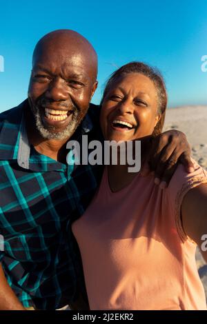 Porträt eines glücklichen, pensionierten afroamerikanischen Seniorenpaares, das am Strand zusammen genießt Stockfoto