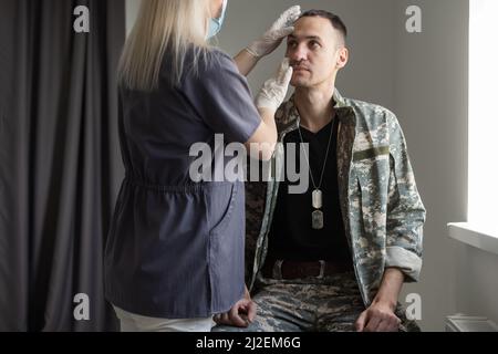 Arzt mit Militäroffizier Patient im Krankenhaus Stockfoto