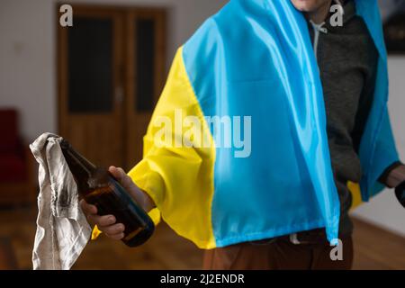 Mans Hand hält Molotov Cocktailflasche. Minimales Ukraine-Konzept. Stockfoto