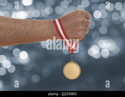 Mann, der die Hand hebt und die Goldmedaille hält. Konzept von Ehrgeiz Ausdauer und Sieg. Stockfoto