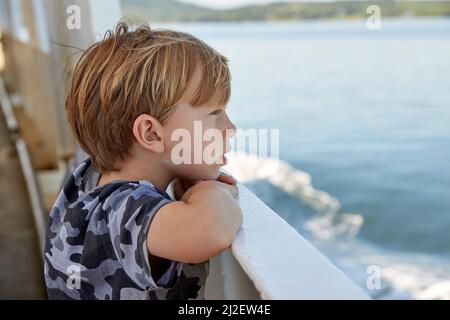 Junge mit Blick auf den Ozean Stockfoto