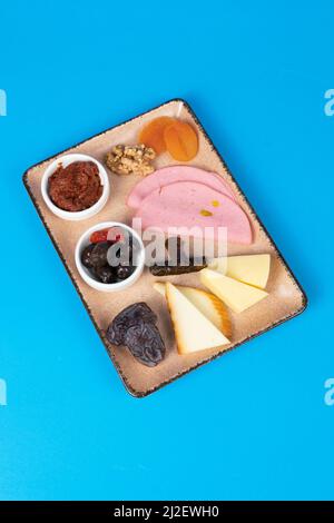 walnüsse, Oliven, Tomatenmark, Käsescheiben, Wrap, Schinken, getrocknete Aprikosen, Dattel- und Cheddar-Käse. Stockfoto