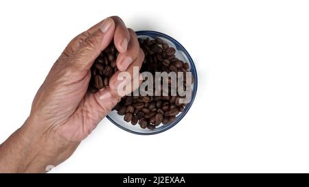 Hand Pick up Kaffeebohnen auf der Hand aus Glas Schüssel, Kaffeebohnen in Glas Schüssel, isoliert auf weißem Hintergrund Stockfoto