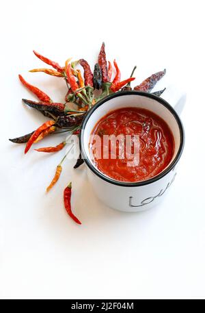 Hausgemachte Tomatensauce und Paprika auf weißem Hintergrund isoliert. Direkt darüber, Kopierbereich. Stockfoto