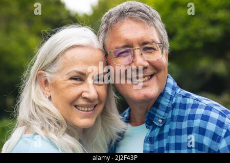 Porträt eines glücklichen kaukasischen Seniorenpaares, das gemeinsam im Hinterhof Freizeit verbringt Stockfoto