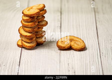 Palmier Blätterteig-Kekse auf einem weißen Holztisch Stockfoto