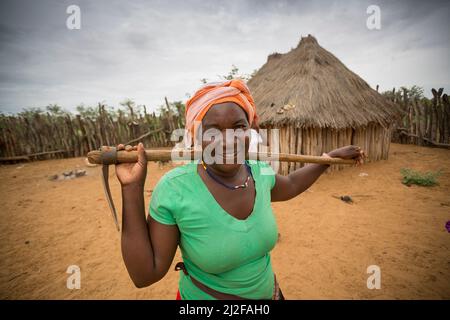 Bäuerin mit Hacke im Dorf Okavandu, Region Omusati, Namibia, Südwestafrika. Stockfoto