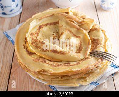 Stapel von dünnen Pfannkuchen oder Crepes auf einem Teller Stockfoto