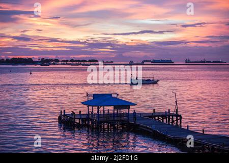 Die Abendsonne untergeht über dem Ozean vor der Küste von Makassar, Indonesien, Asien. Stockfoto