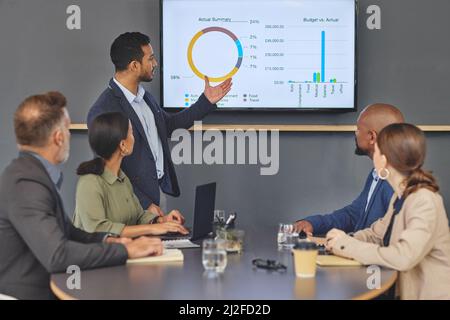 Geschäftsgespräche sind immer ernst. Aufnahme einer Gruppe von Geschäftsleuten, die bei der Arbeit in einem Sitzungssaal ein Meeting abhalten. Stockfoto