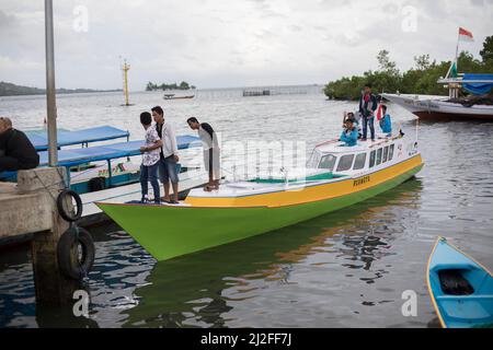 Ein Fischerboot voller Passagiere fährt bis zu den Docks in Mamuju City, auf der Insel Sulawesi, Indonesien, Asien. Stockfoto