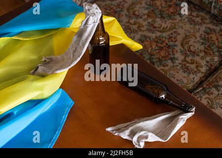 Molotow Cocktail, Kriegsrecht in der Ukraine, eine brennbare Mischung in Flaschen mit einem Lappen liegt auf der Flagge der Ukraine, Krieg Ukraine 2022 Stockfoto