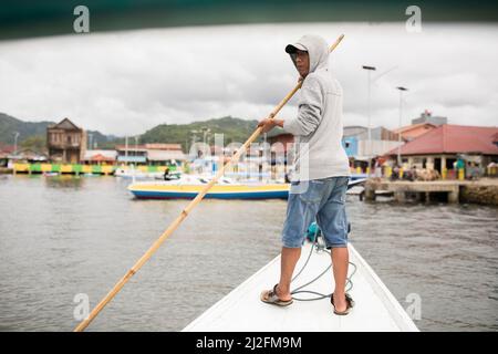 Der Bootsführer steuert durch den Hafen und legt in Mamuju City, Sulawesi, Indonesien, Asien an. Stockfoto