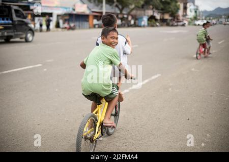 Kinder fahren auf den Straßen von Mamuju, Indonesien, mit dem Fahrrad. Stockfoto