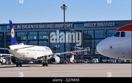 28. März 2022, Brandenburg, Schönefeld: Ein Passagierflugzeug der Lufthansa vor dem Terminal des Hauptstadtflughafens Berlin-Brandenburg (BER). Foto: Patrick Pleul/dpa-Zentralbild/ZB Stockfoto