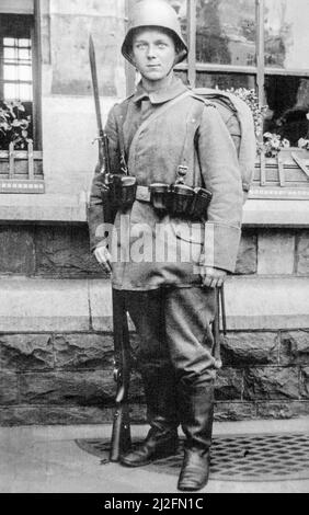 Junger deutscher bayerischer Infanteriesoldat / Infanterist, der 1917 während des Ersten Weltkriegs im Kampfkleid mit Gewehr, Bajonett und stahlhelm posiert Stockfoto