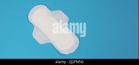 Damenbinden auf blauem Hintergrund. Draufsicht. Saugfähige Pads, die von Frauen zur Aufnahme von Menstruationsblut getragen werden. Bequeme weiße Sanitärservietten arrangiert Stockfoto