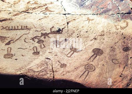 Alte Felszeichnungen am Ufer des Onega-Sees. Geschnitzt auf einer Granitplatte. Kap Besov Nos, Karelien, Russland - 15. August 2021. Stockfoto