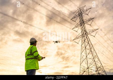 Standort der Ingenieure Verwenden Sie Drohnen, um Inspektionen im Kraftwerk zu fliegen, um die Planungsarbeiten durch die Produktion von Hochspannungselektrik zu sehen Stockfoto