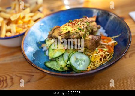 Hähnchenspieße und gemischter Salat auf einem Teller Stockfoto