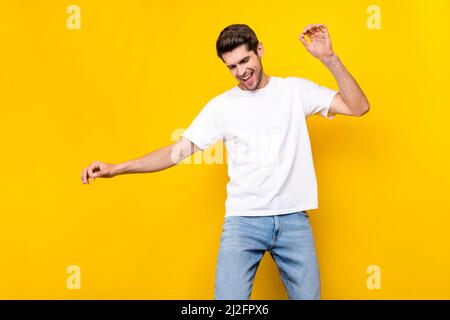 Foto von niedlichen Millennial Brunet Kerl Tanz tragen T-Shirt Jeans isoliert auf gelbem Hintergrund Stockfoto