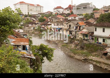 In Yogyakarta (Jogjakarta), der zweitgrößten Stadt Indonesiens, befinden sich überfüllte, farbenfrohe Slumhäuser an einem Abwasserabfluss-Kanal. Stockfoto