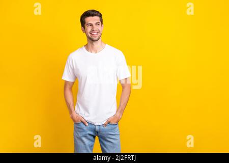 Foto von interessierten Millennial Brunet guy Look promo tragen casual Tuch isoliert auf gelbem Hintergrund Stockfoto