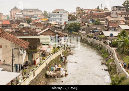 In Yogyakarta (Jogjakarta), der zweitgrößten Stadt Indonesiens, befinden sich überfüllte, farbenfrohe Slumhäuser an einem Abwasserabfluss-Kanal. Stockfoto