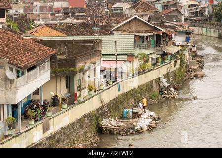 In Yogyakarta (Jogjakarta), der zweitgrößten Stadt Indonesiens, befinden sich überfüllte, farbenfrohe Slumhäuser an einem Abwasserabfluss-Kanal. Stockfoto