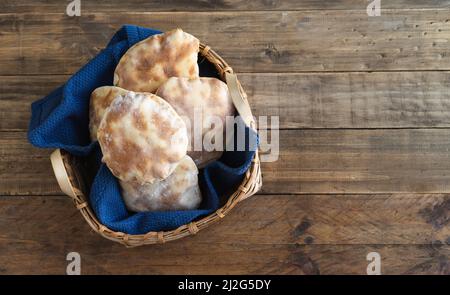 Korb mit hausgemachtem Pita-Brot auf alten Holzbrettern. Kopierbereich, Draufsicht. Stockfoto