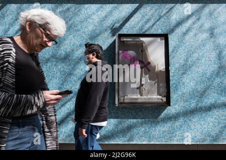 Seattle, USA. 31. März 2022. Menschen, die an einem verwüsteten Schild in Cinerama in Belltown vorbeikommen. Stockfoto