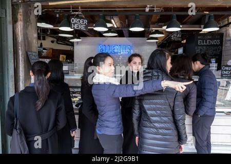 Seattle, USA. 31. März 2022. Ellenos in Pike Place Market mit einem Touristen, der nach Aufhebung der Zwangsbeschränkungen zeigt. Stockfoto