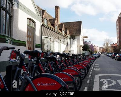 London, Greater London, England, März 12 2022: Santander mietet Fahrräder alias Boris Bikes in der Nähe der Kings Road vor einem Gebäude mit Treppenzugang. Stockfoto