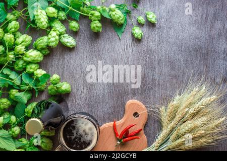 Flasche und Glas Bier mit Weizen und Hopfen als Brauzutaten in Draufsicht und Kopierraum Stockfoto