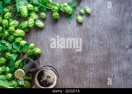 Flasche und Glas Bier mit Zutaten für die Zubereitung. Hopfenblüte mit Weizen. Draufsicht. Stockfoto