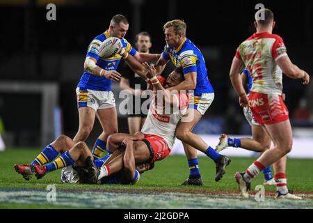 Agnatius Paasi #17 von St. Helens wird von Matt Prior #10, Cameron Smith #17 und Rhyse Martin #12 von Leeds Rhinos angegangen Stockfoto