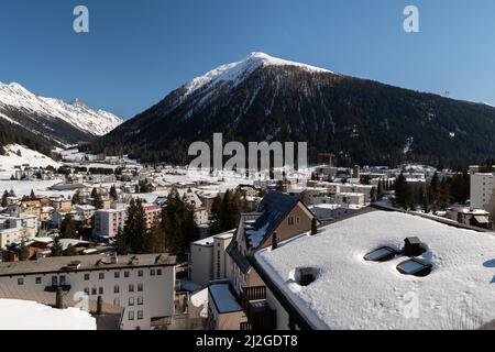 Davos, Schweiz, 23. März 2022 Blick über die Stadt und die faszinierenden schneebedeckten alpen an einem klaren, blauen Himmelstag Stockfoto