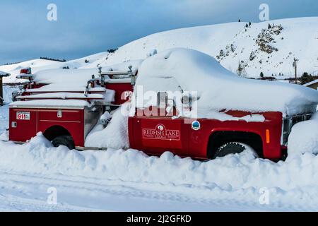 Stanley, ID USA - 28 Dec 2021: Feuerwehrauto der Red Fish Lake Lodge, vergraben im Schnee in den Triangle C Cabins Stockfoto