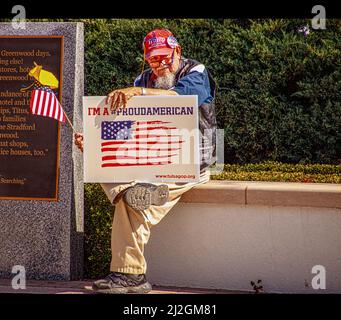 2022 )3 05 Tulsa OK USA - Senior man mit Trump-Hut und GOP-Schild sitzt mit US- und ukrainischen Flaggen im Reconciliation Park bei der pro-ukrainischen Kundgebung Stockfoto